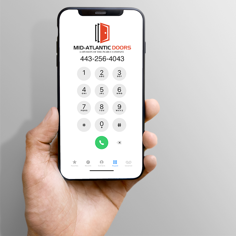 A hand holding a phone with the Mid-Atlantic Doors logo and phone number - (301) 712-5228